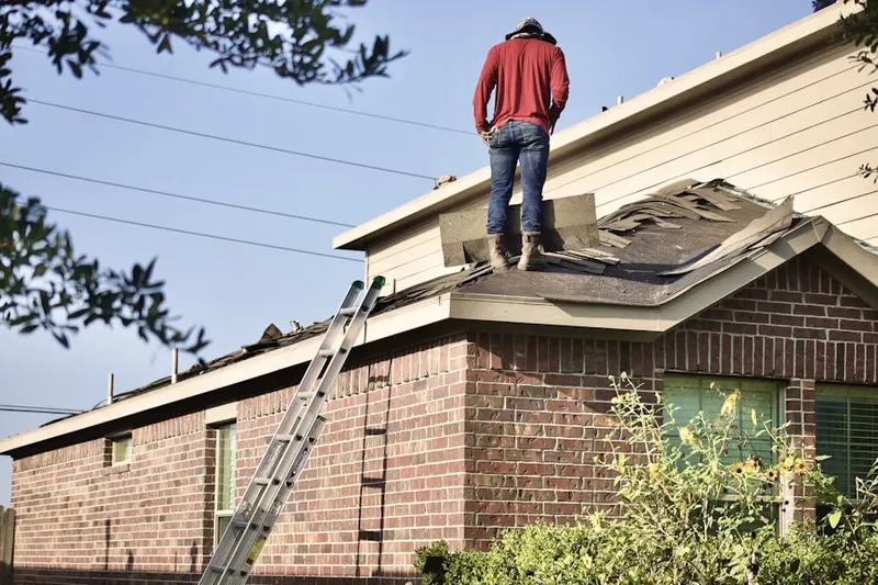 Professional roofer working on a residential roof in Manhasset